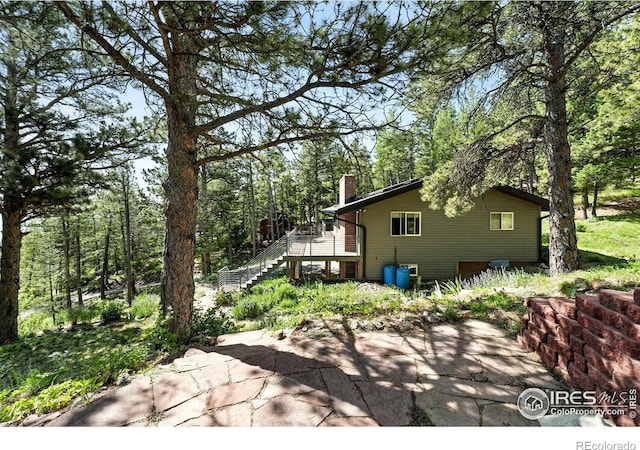 74 Sky Trail Rd, Boulder, CO 80302 - view of property exterior with stairway, a chimney, a deck, and a patio area