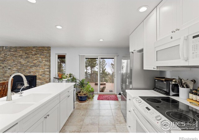 74 Sky Trail Rd, Boulder, CO 80302 - kitchen with white microwave, electric range oven, white cabinets, recessed lighting, and light countertops