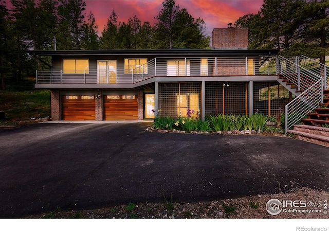 74 Sky Trail Rd, Boulder, CO 80302 - view of front of house featuring brick siding, driveway, an attached garage, stairway, and a chimney