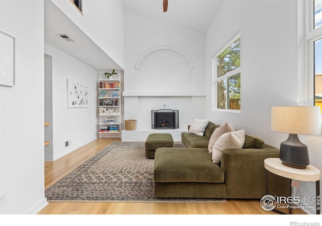 586 Aztec Dr, Boulder, CO 80303 - living area with high vaulted ceiling, wood finished floors, a fireplace, baseboards, and visible vents