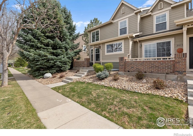 view of front of house featuring a front lawn and brick siding