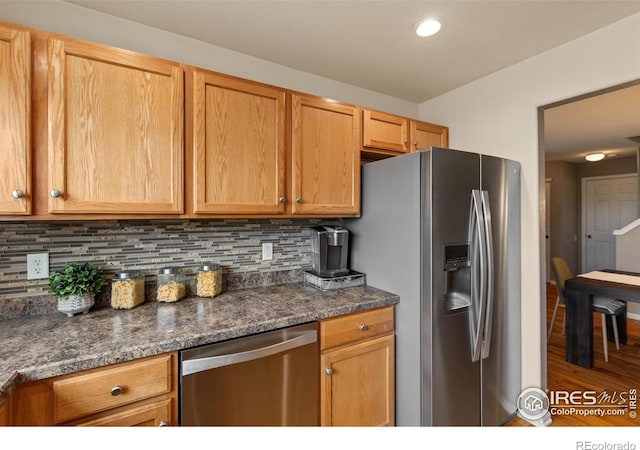 kitchen featuring recessed lighting, tasteful backsplash, wood finished floors, and stainless steel appliances