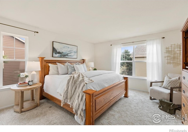 bedroom featuring light carpet and baseboards
