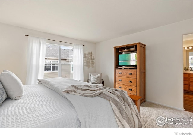 bedroom featuring light colored carpet and baseboards