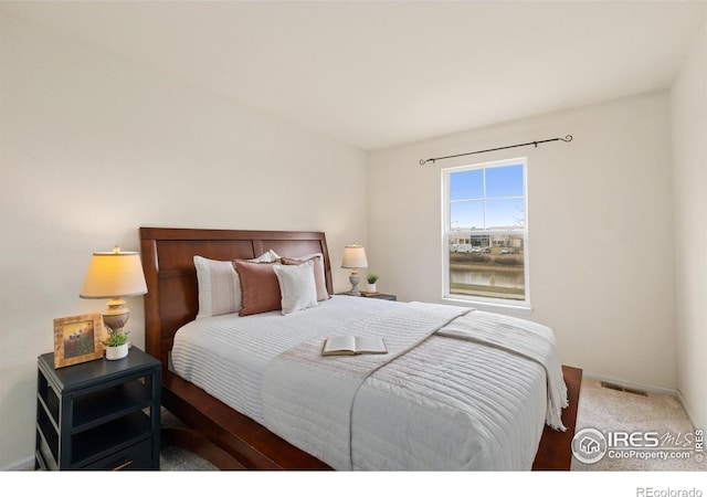 carpeted bedroom with baseboards and visible vents