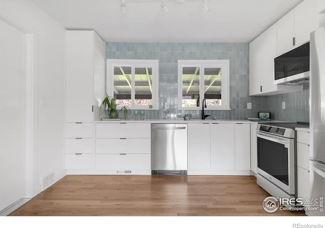 220 28th St, Boulder, CO 80305 - kitchen featuring light countertops, white cabinets, stainless steel appliances, and visible vents