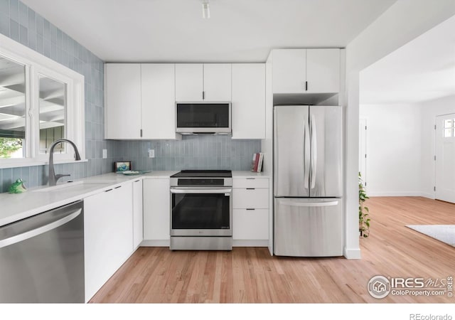 220 28th St, Boulder, CO 80305 - kitchen with light countertops, light wood-style flooring, stainless steel appliances, and white cabinetry