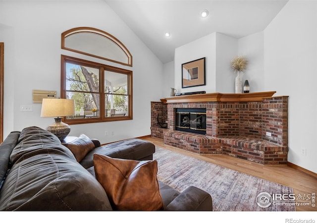 living area featuring a fireplace, recessed lighting, baseboards, wood finished floors, and vaulted ceiling