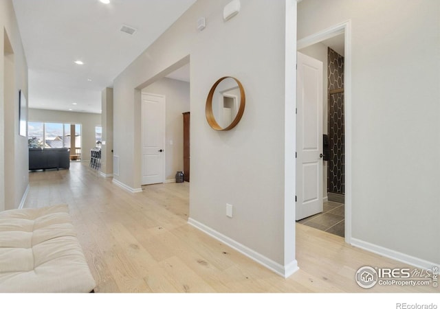 3351 Heron Lakes Pkwy, Berthoud, CO 80513 - hall featuring arched walkways, baseboards, recessed lighting, and light wood-style flooring