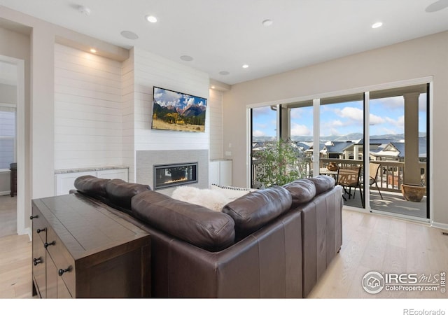 3351 Heron Lakes Pkwy, Berthoud, CO 80513 - living area with recessed lighting, a glass covered fireplace, and light wood-style flooring