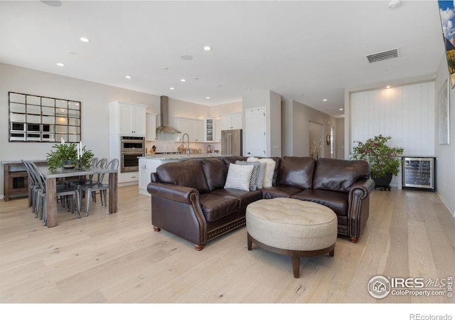 3351 Heron Lakes Pkwy, Berthoud, CO 80513 - living room featuring recessed lighting, beverage cooler, visible vents, and light wood-style flooring