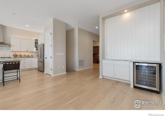 3351 Heron Lakes Pkwy, Berthoud, CO 80513 - unfurnished living room featuring recessed lighting, light wood-style floors, visible vents, and wine cooler