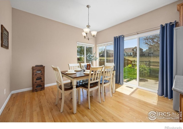 dining room featuring visible vents, baseboards, an inviting chandelier, and light wood finished floors