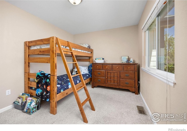 bedroom with baseboards, light carpet, and visible vents