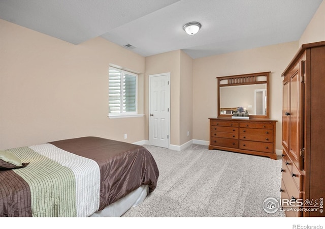bedroom featuring baseboards, light colored carpet, and visible vents