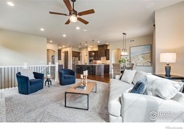 living room featuring a ceiling fan, arched walkways, recessed lighting, and visible vents