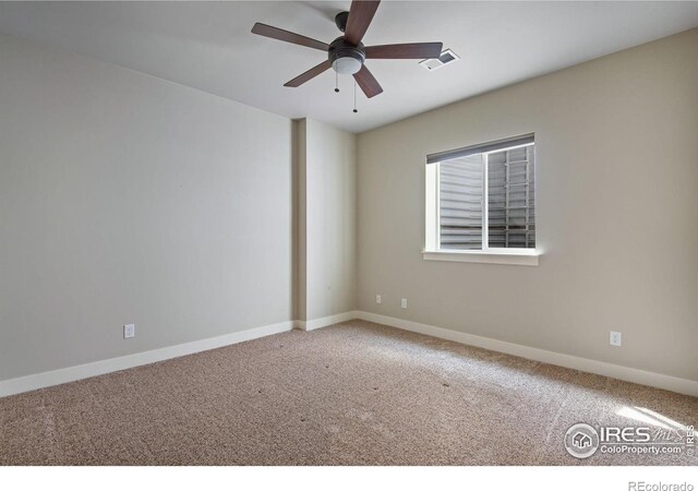empty room featuring baseboards, ceiling fan, carpet flooring, and visible vents