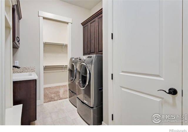 6297 Crooked Stick Dr, Windsor, CO 80550 - washroom with cabinet space, separate washer and dryer, and baseboards