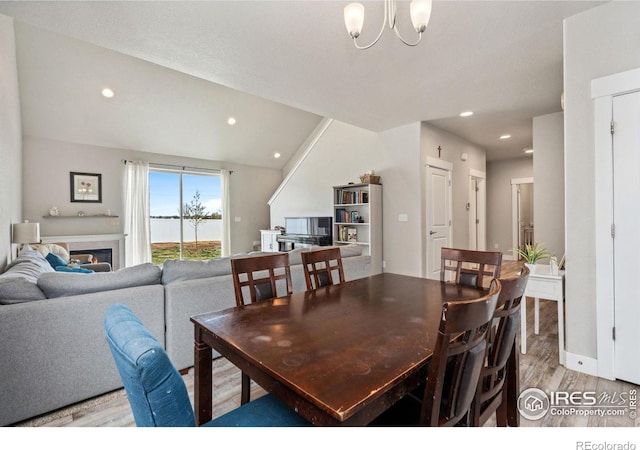 1030 Grand Ave, Windsor, CO 80550 - dining room with a chandelier, a glass covered fireplace, recessed lighting, and light wood-style floors