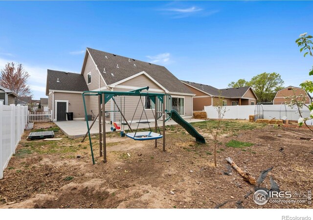 1030 Grand Ave, Windsor, CO 80550 - rear view of house with a patio area, a fenced backyard, and a playground