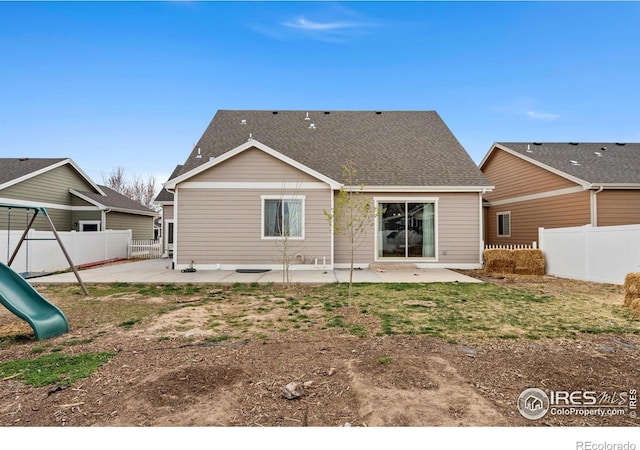 1030 Grand Ave, Windsor, CO 80550 - back of house with roof with shingles, fence, a patio area, and a playground