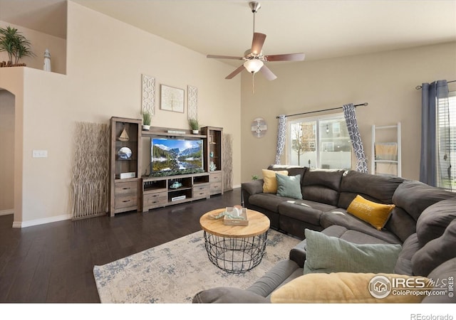 2433 Tabor St, Berthoud, CO 80513 - living room featuring ceiling fan, hardwood / wood-style floors, baseboards, arched walkways, and a high ceiling
