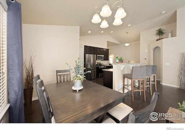 2433 Tabor St, Berthoud, CO 80513 - dining area with a chandelier, dark wood finished floors, arched walkways, baseboards, and high vaulted ceiling