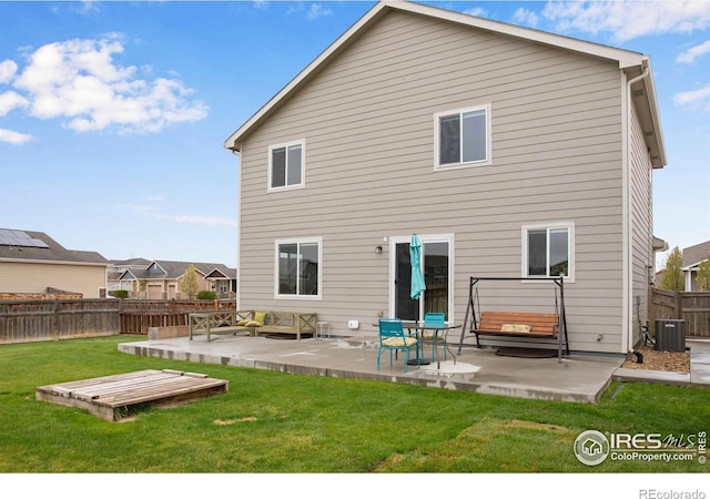 1484 Moraine Valley Dr, Severance, CO 80550 - rear view of house featuring a lawn, central AC unit, a wooden deck, a fenced backyard, and a patio