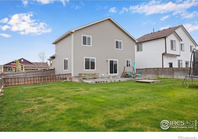 1484 Moraine Valley Dr, Severance, CO 80550 - rear view of property with a yard, a fenced backyard, a patio area, and a trampoline