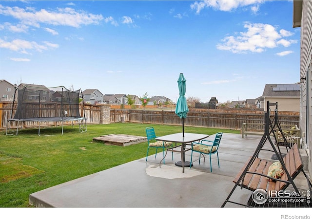 1484 Moraine Valley Dr, Severance, CO 80550 - view of patio / terrace with outdoor dining area, a fenced backyard, a trampoline, and a residential view