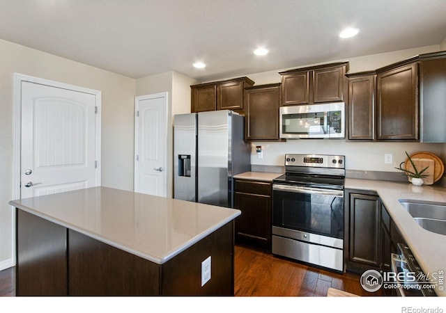 1484 Moraine Valley Dr, Severance, CO 80550 - kitchen featuring a center island, dark wood finished floors, appliances with stainless steel finishes, and dark brown cabinets