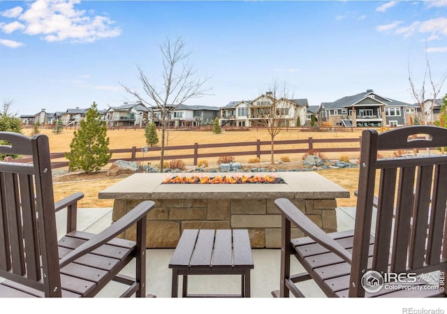 exterior space featuring a residential view, an outdoor fire pit, and fence