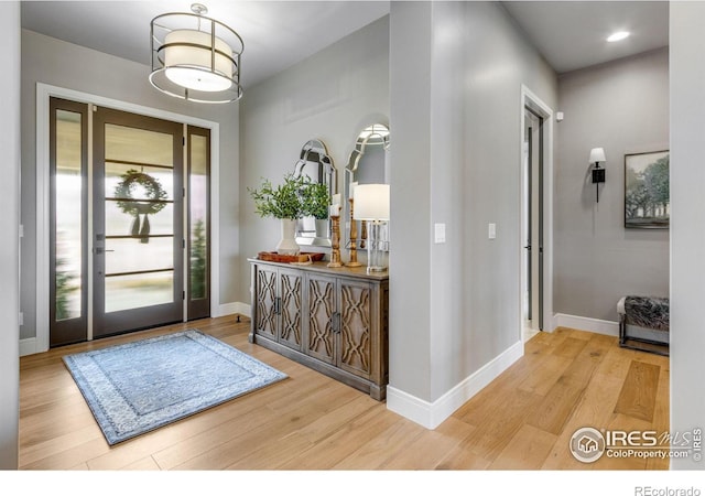 foyer entrance featuring baseboards, wood finished floors, and recessed lighting