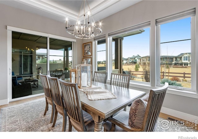 dining room with wood finished floors, baseboards, and a notable chandelier