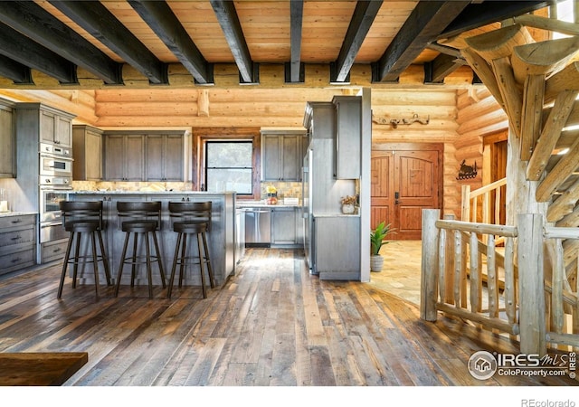 4 Dill Pickle Pl, Black Hawk, CO 80422 - kitchen with a warming drawer, dark wood-style flooring, beamed ceiling, wooden ceiling, and a breakfast bar