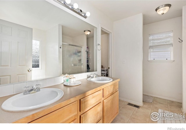 bathroom with visible vents, a sink, a shower stall, and double vanity