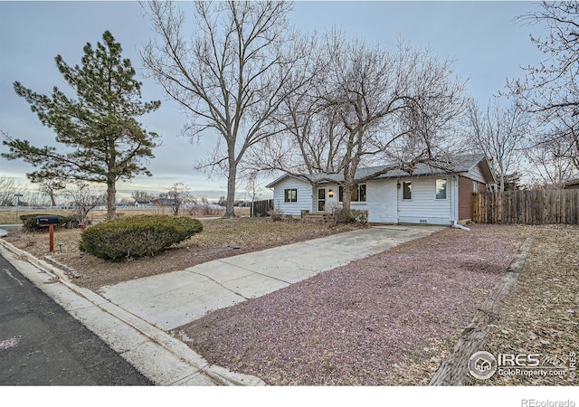 ranch-style home with fence and driveway