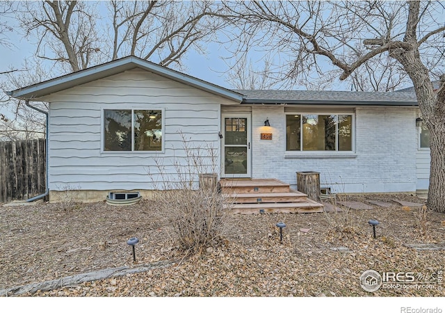 single story home with brick siding, crawl space, fence, and a shingled roof