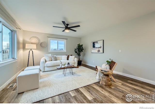living room featuring ceiling fan, baseboards, wood finished floors, and visible vents