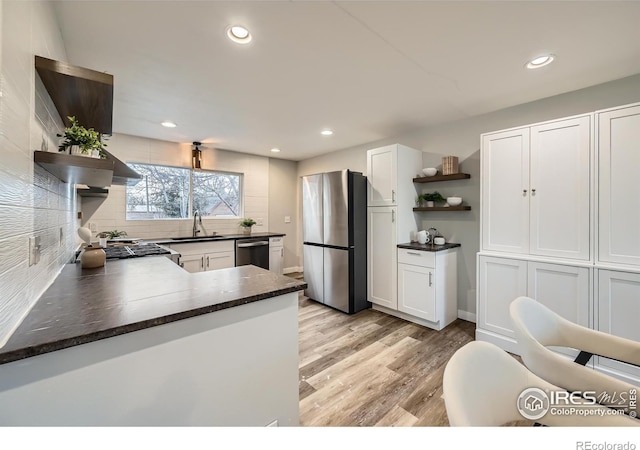 kitchen with open shelves, a sink, stainless steel appliances, light wood finished floors, and white cabinets
