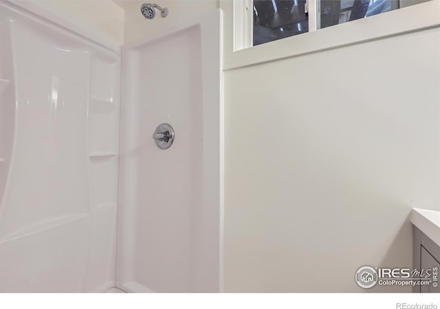 bathroom with walk in shower and vanity