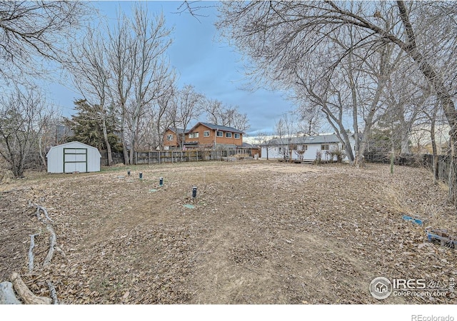 view of yard with a fenced backyard, an outbuilding, and a shed