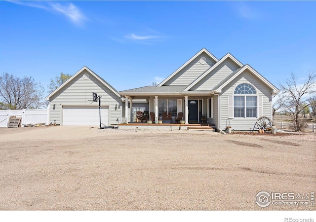 view of front of property featuring a porch, driveway, fence, and a garage