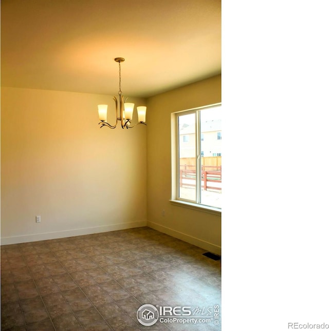 8710 8th St, Greeley, CO 80634 - unfurnished room featuring a chandelier and baseboards