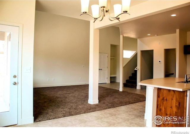 8710 8th St, Greeley, CO 80634 - kitchen with light colored carpet, recessed lighting, light countertops, a chandelier, and pendant lighting