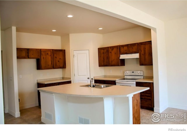 8710 8th St, Greeley, CO 80634 - kitchen with white electric range, under cabinet range hood, light countertops, recessed lighting, and an island with sink
