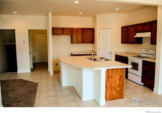 8710 8th St, Greeley, CO 80634 - kitchen with white electric range, under cabinet range hood, an island with sink, light countertops, and recessed lighting