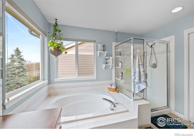 bathroom featuring a shower stall and a bath