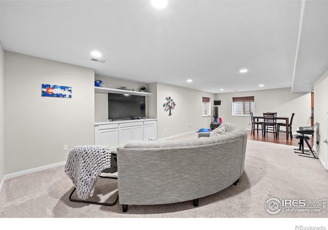 living room with carpet floors, recessed lighting, baseboards, and visible vents