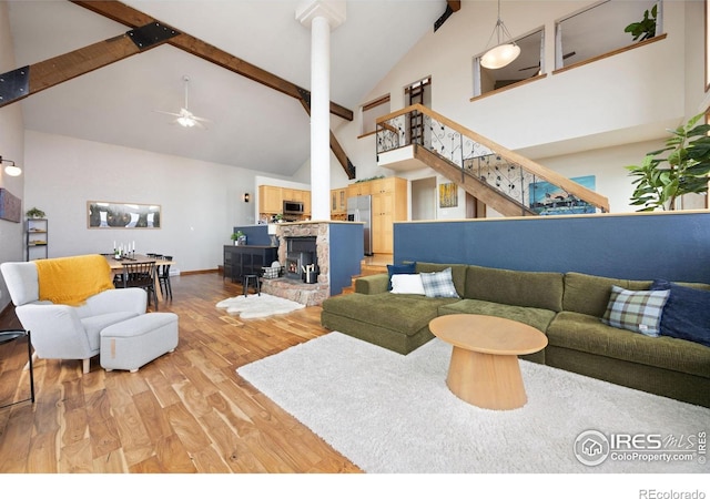 810 Manhead Mountain Dr, Livermore, CO 80536 - living area featuring light wood finished floors, high vaulted ceiling, beamed ceiling, stairway, and baseboards